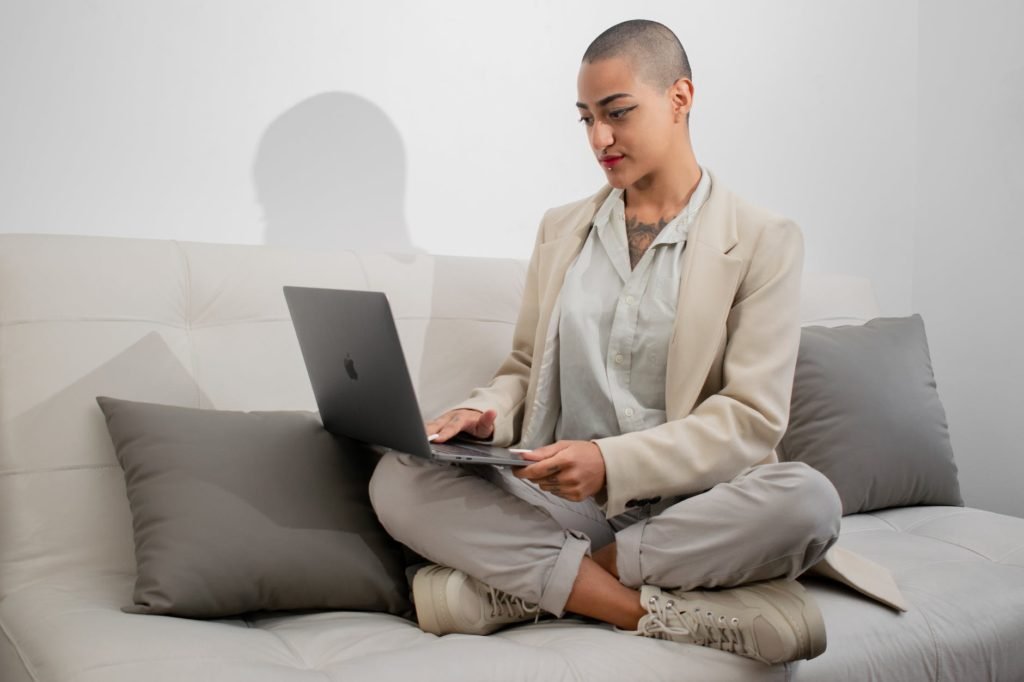 woman sitting on a couch using a laptop