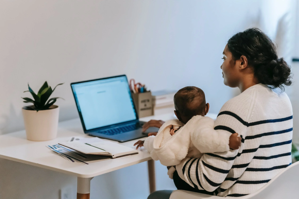 5. Graphic Design For Unique Products. pic of a mom using a laptop while holding a baby.