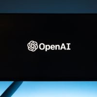 monitor screen with openai logo on black background: Does ChatGPT API Cost Money & How Much?