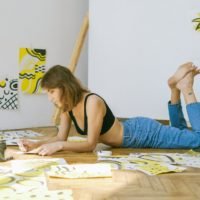photo of woman lying on floor while painting: Liste de passions hobbies pour femmes