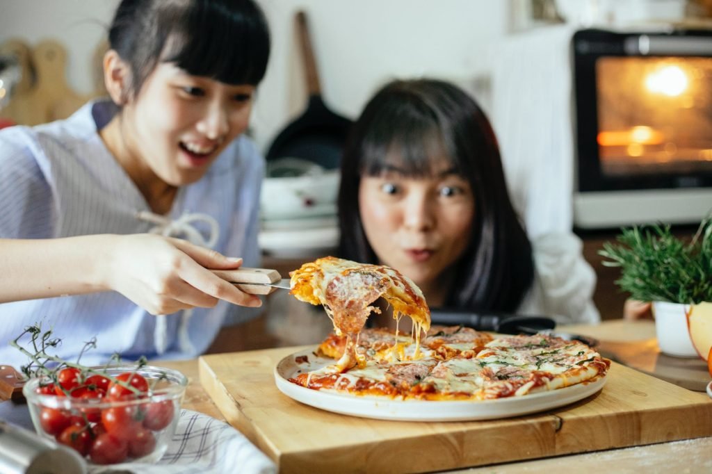 joyful ethnic women cooking pizza together: How to Make Money Online from Cooking (Guided Steps)
