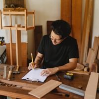 Professional craftsman sketching new project on paper: how to sell wood projects online (best ways & steps)