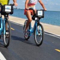 girl in pink shorts and black shirt riding on bicycle on road - topic: meilleures marques de vélo de route