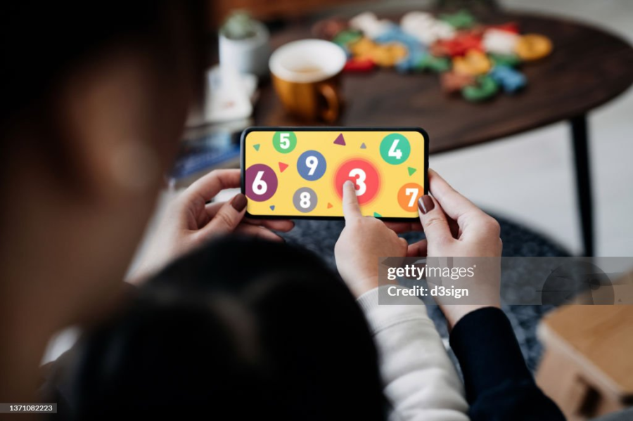 mother teach his son/daughter on a mobile game