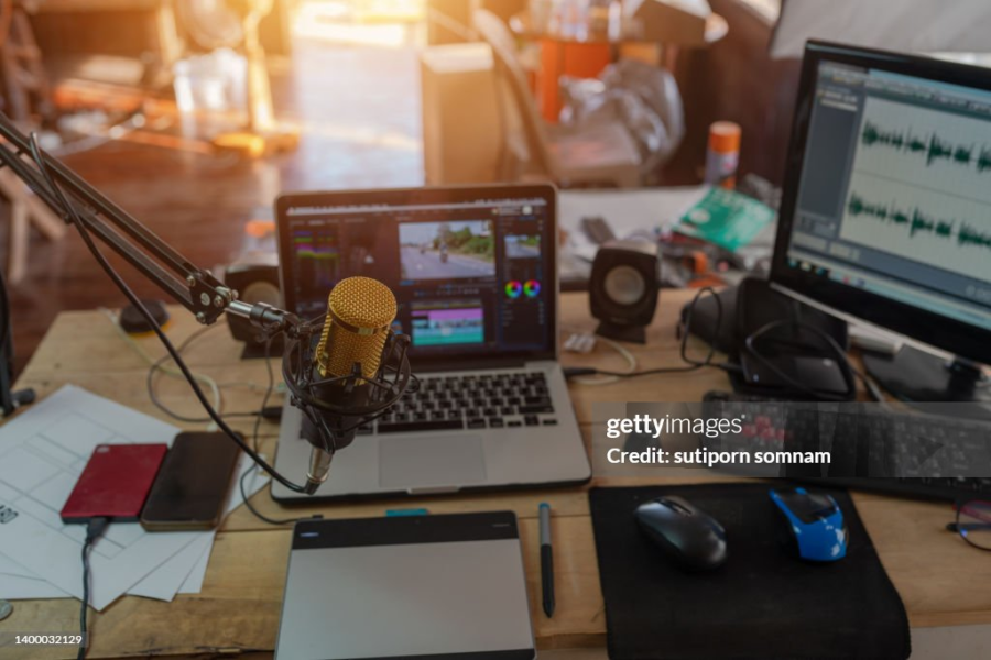 content creation materials: pc, microphone, laptop, phones on a desk