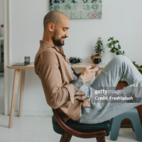 How to Rewrite Formal to Casual Text & Emails - Pic: man sitting comfortably in a chair while texting on his smartphone