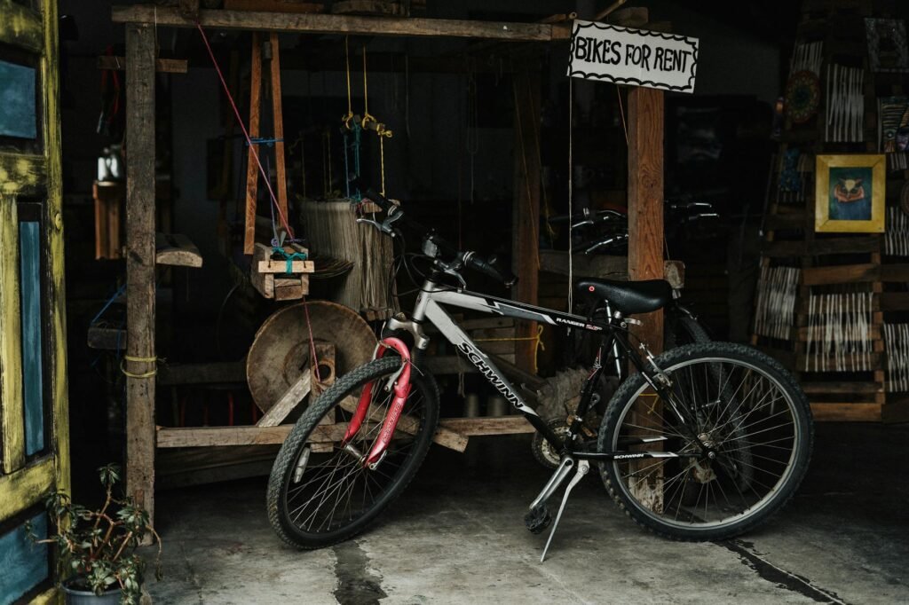 mountain bike to rent in front of a rustic spinning wheel